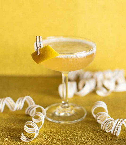 A BARE 75 Zero-Proof Cocktail on a table, made with BARE ZERO PROOF® Modern Classic Gin